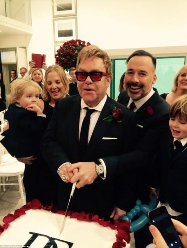 David Furnish and Elton John cut their cake decorated in red roses amongst their friends and family.